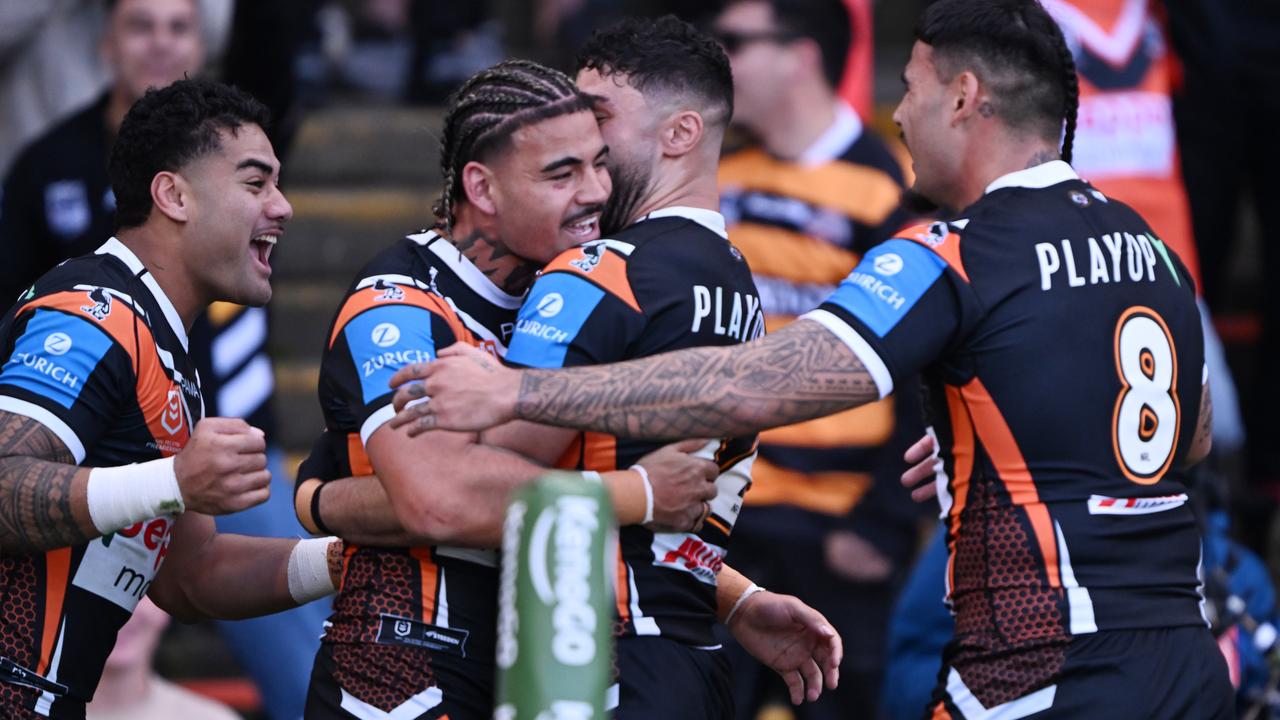 Wests Tigers players celebrate Taylan May's try.