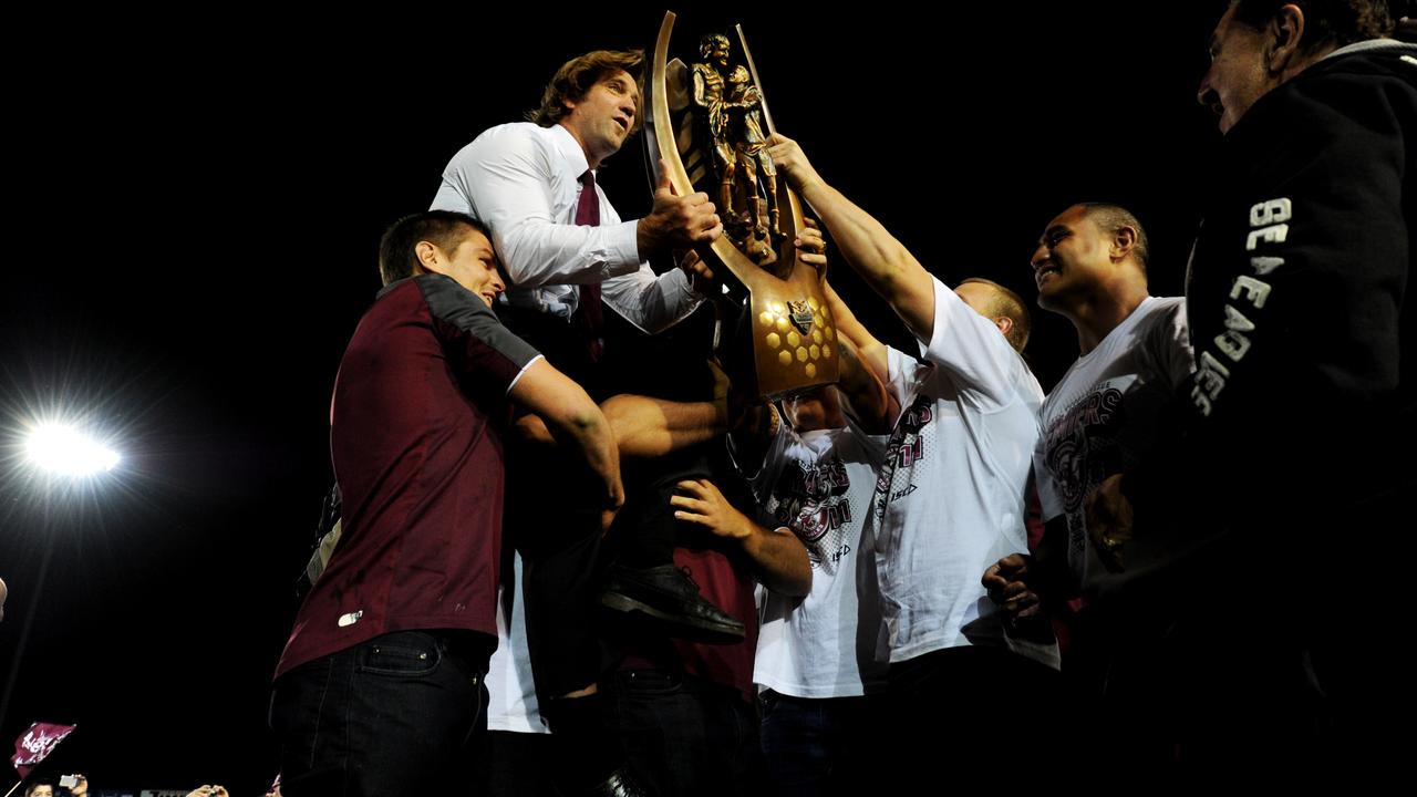 Manly players raise their coach Des Hasler up.