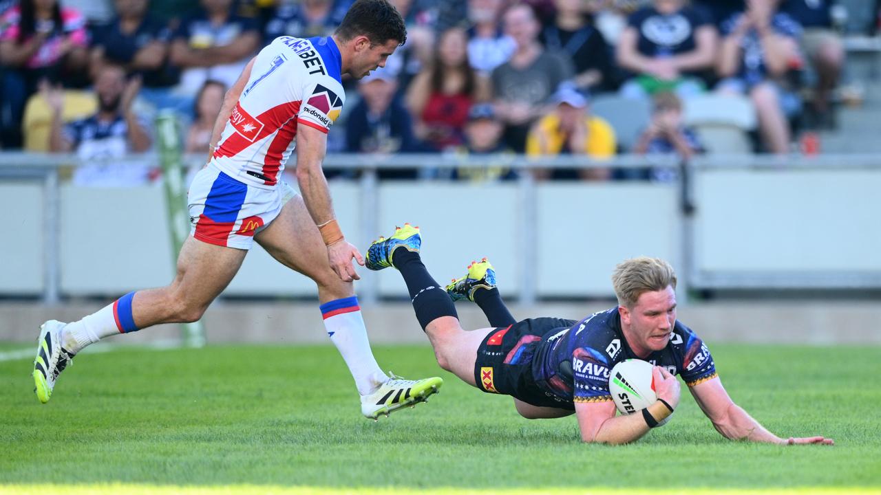 Tom Dearden of the Cowboys crossing for a try.