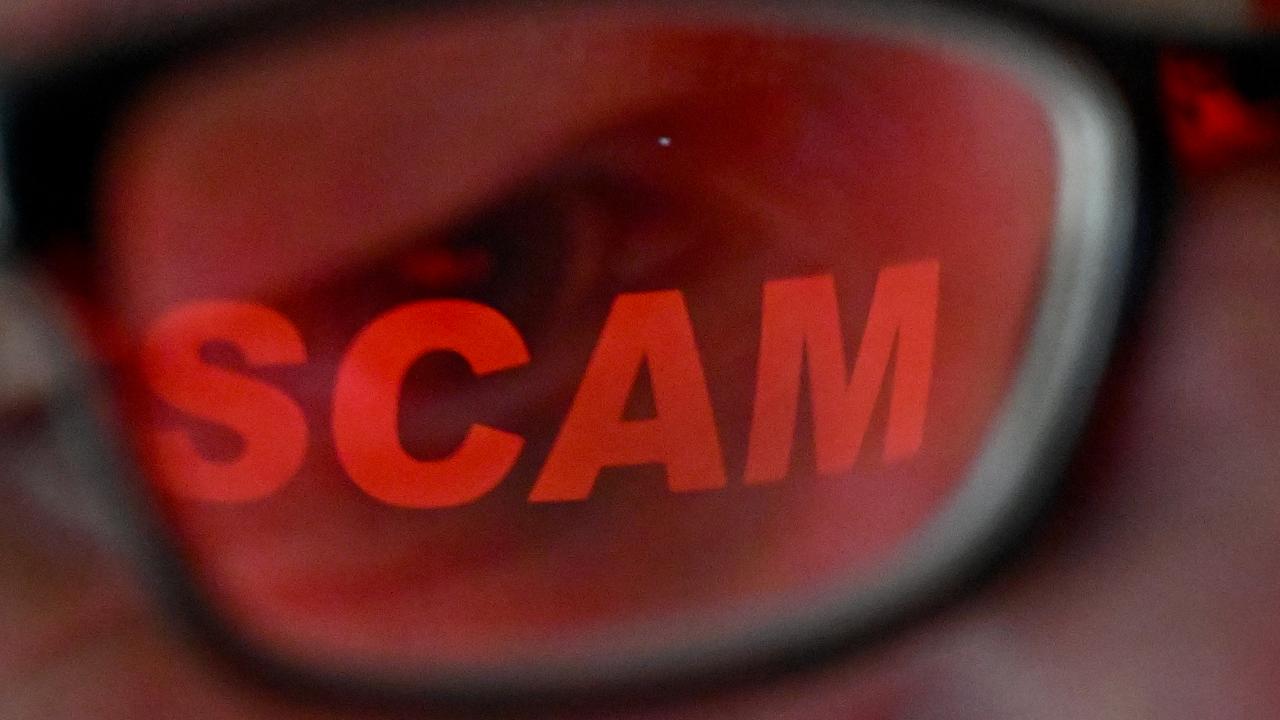 The word 'scam' reflected in a person's glasses (file image)