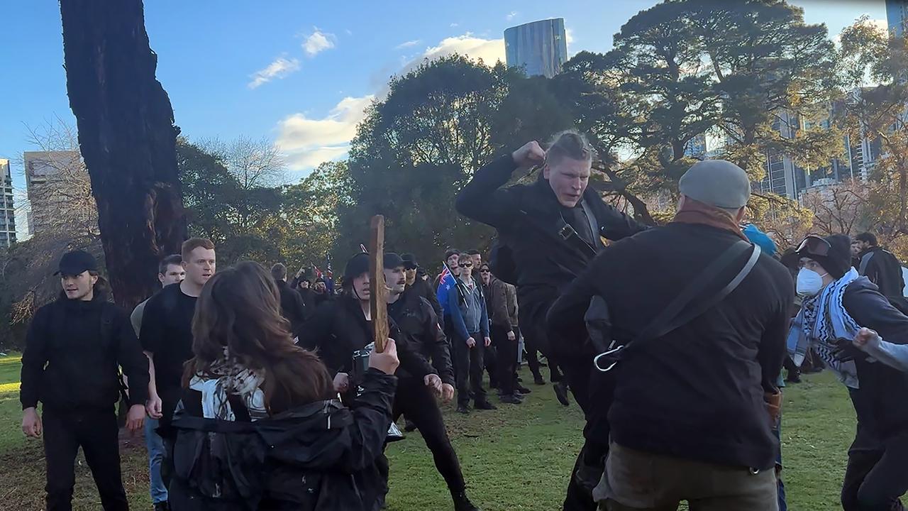 a group of men dressed in black lash out at people at Camp Sovereignty