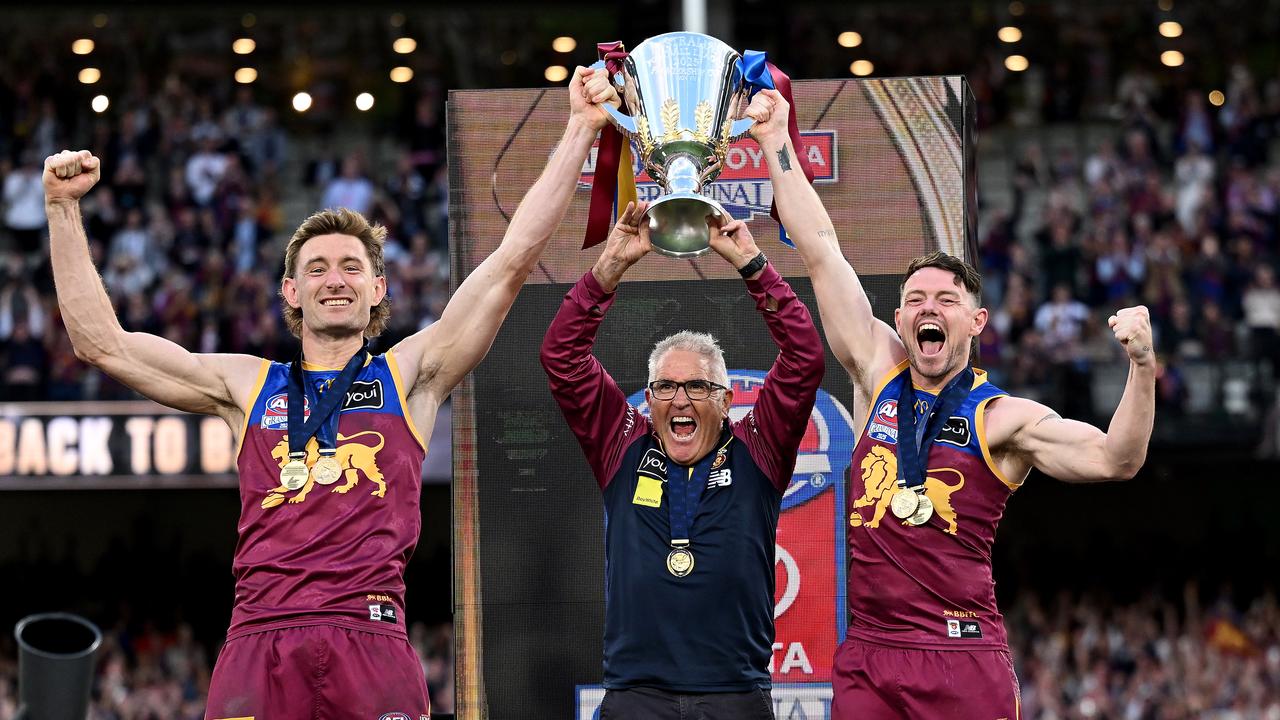 Harris Andrews, Chris Fagan and Lachie Neale hoist the trophy.