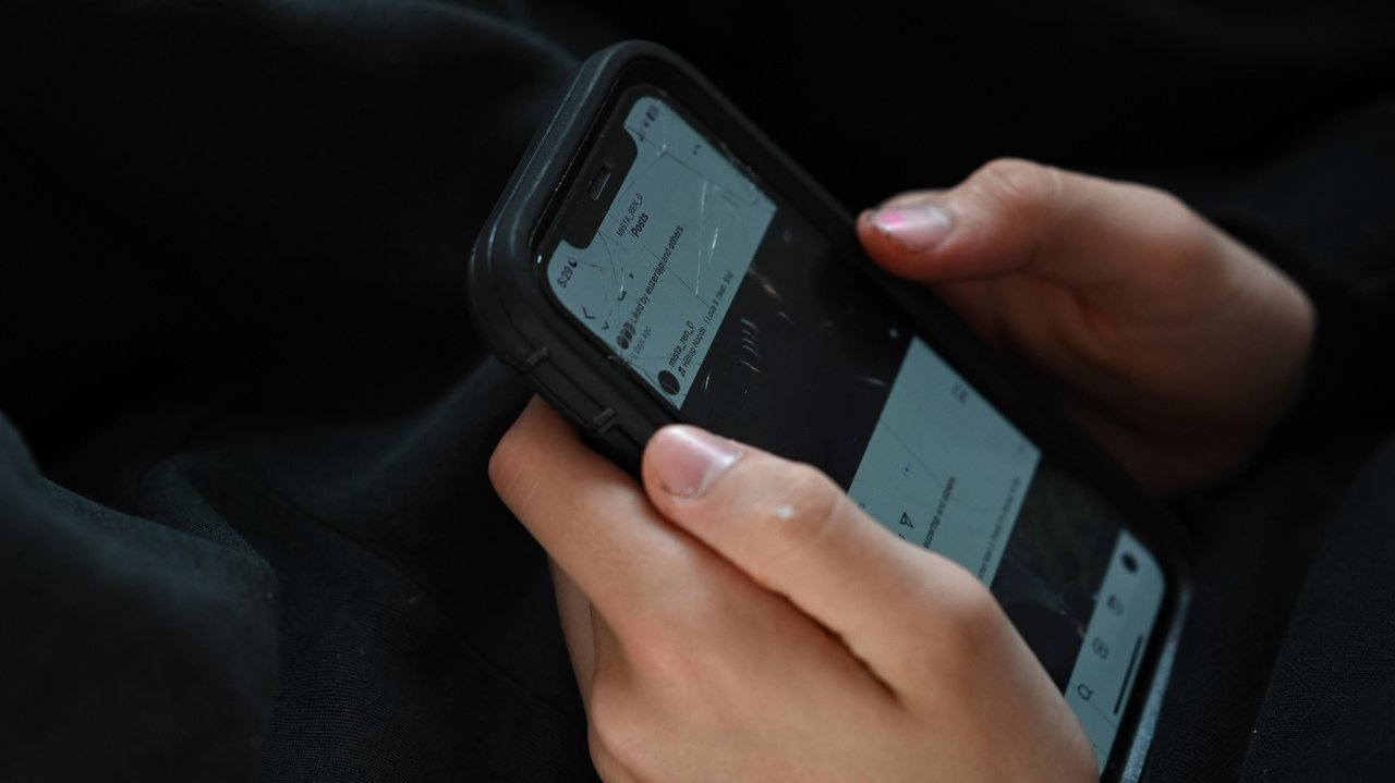 A teenager uses his mobile phone