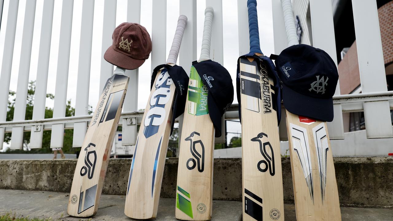 Cricket bats and caps on the boundary fence