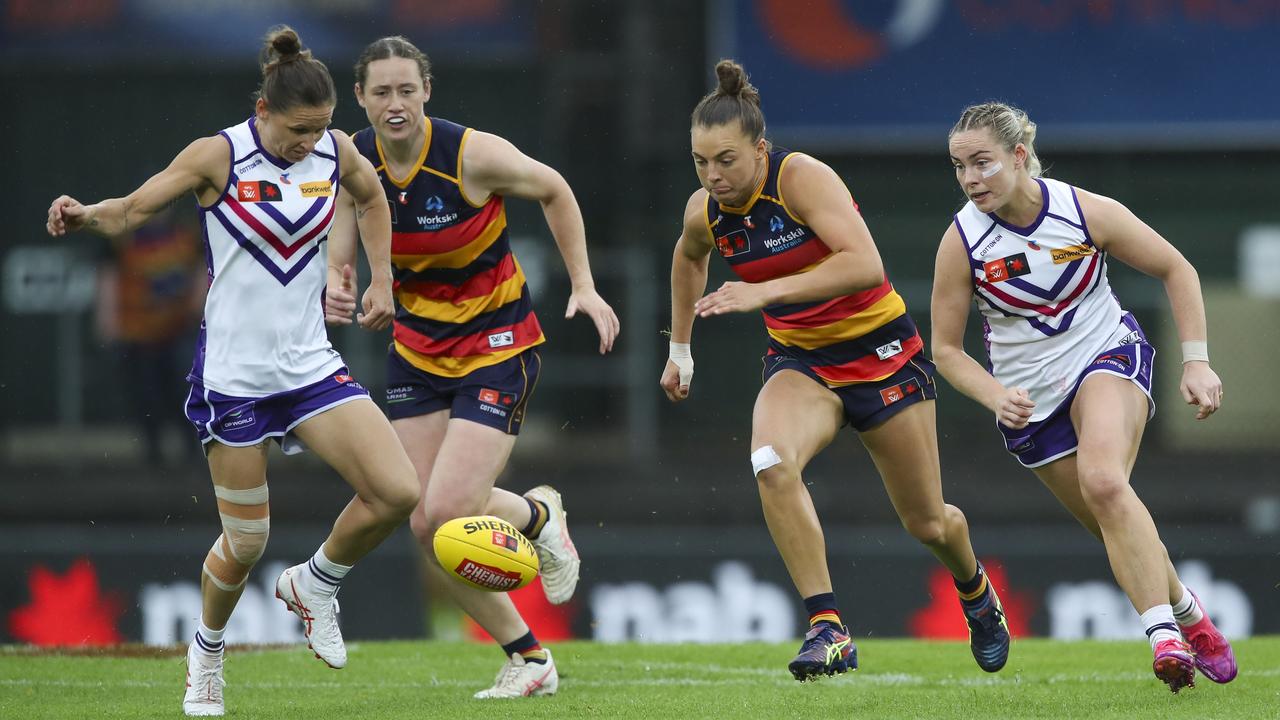 Kiara Bowers and Aisling McCarthy surround Adelaide's Ebony Marinoff.