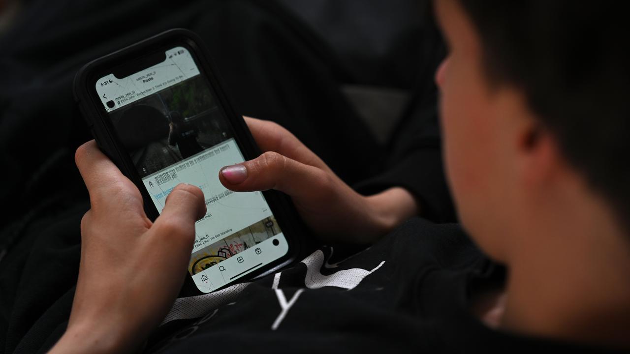 A teenager uses his mobile phone