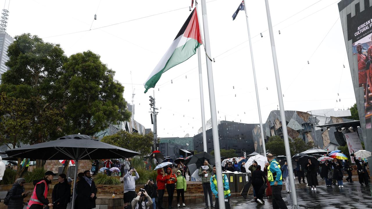 People watch on as the Palestinian flag is raised at Federation Square