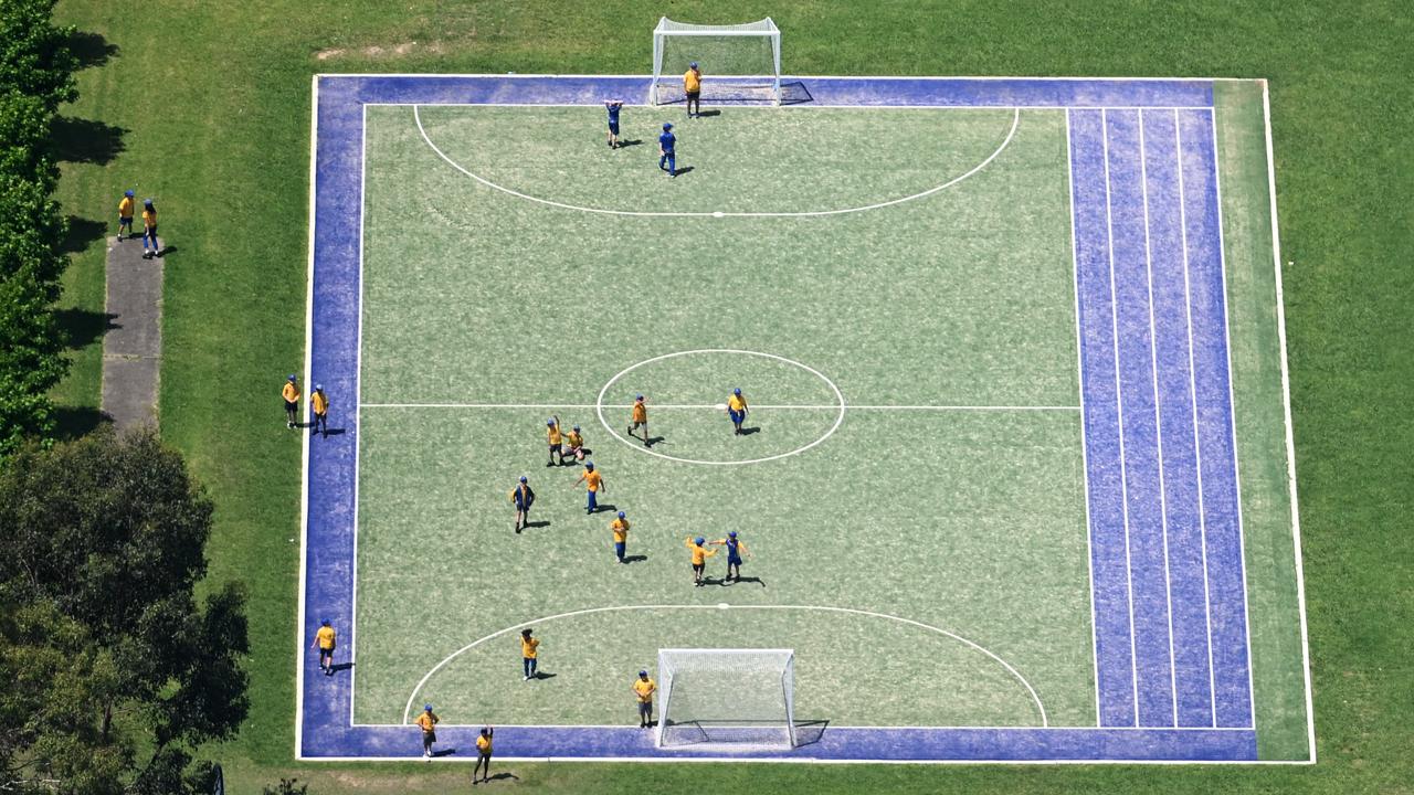 School students play on an astro turf soccer field