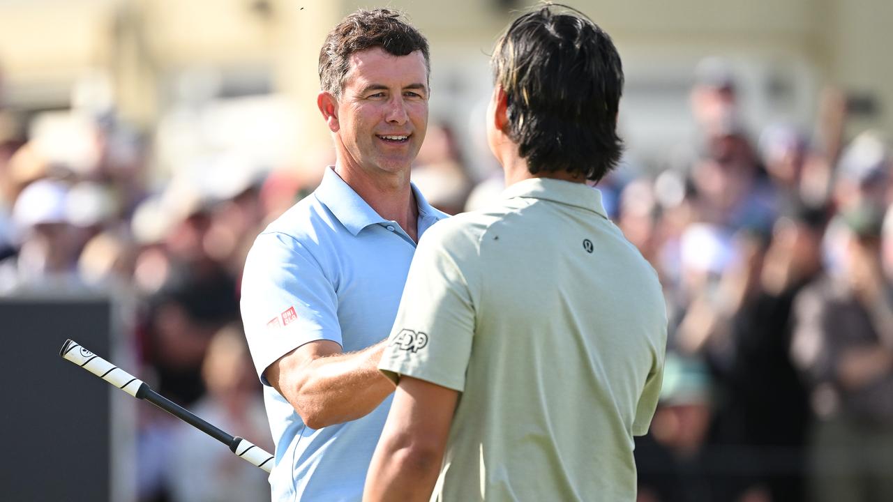 Adam Scott and Min Woo Lee shake hands.