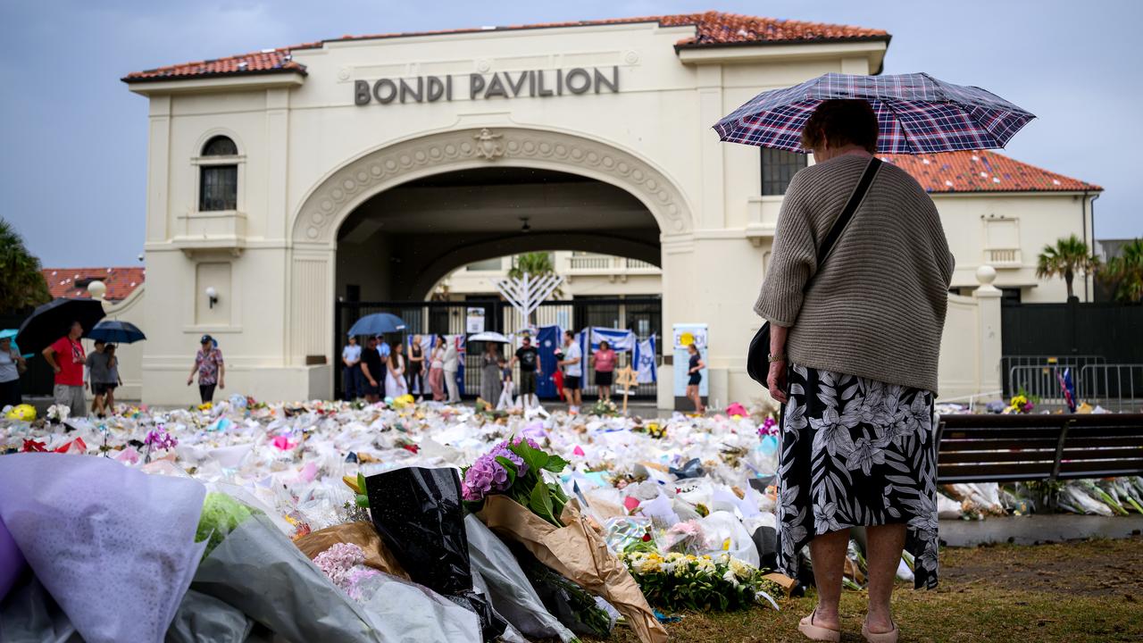 A woman lays flowers at Bondi