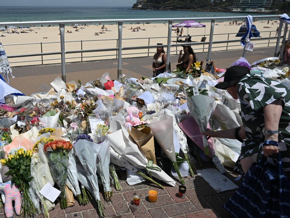 People continue to bring flowers to the Bondi Beach promenade