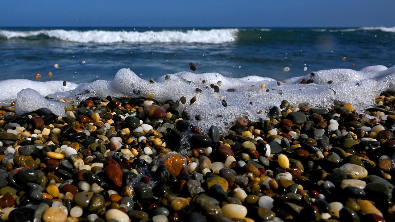 Waves washing across pebbles on a beach (file)