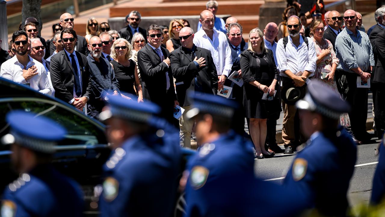 Mourners stand in a line of honour