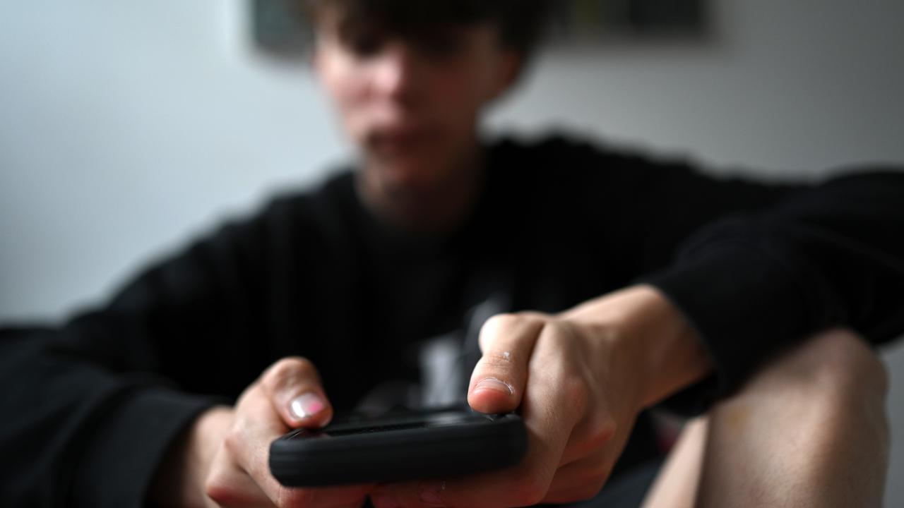 A teenager uses his mobile phone to access social media, Sydney