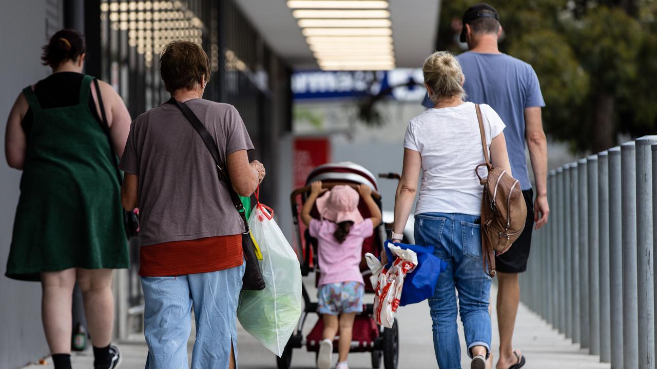 People carry plastic shopping bags outside a shopping centre