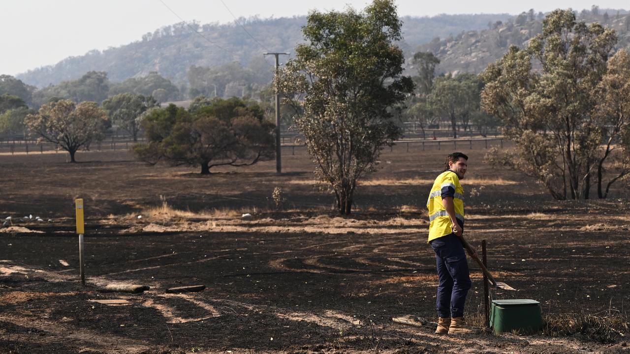 A worker checks water supply in the bushfire affected town of Longwood