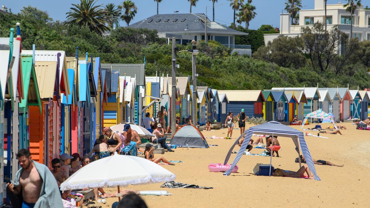 Swimmers seek the shade the Brighton Beach Boxes in Melbourne