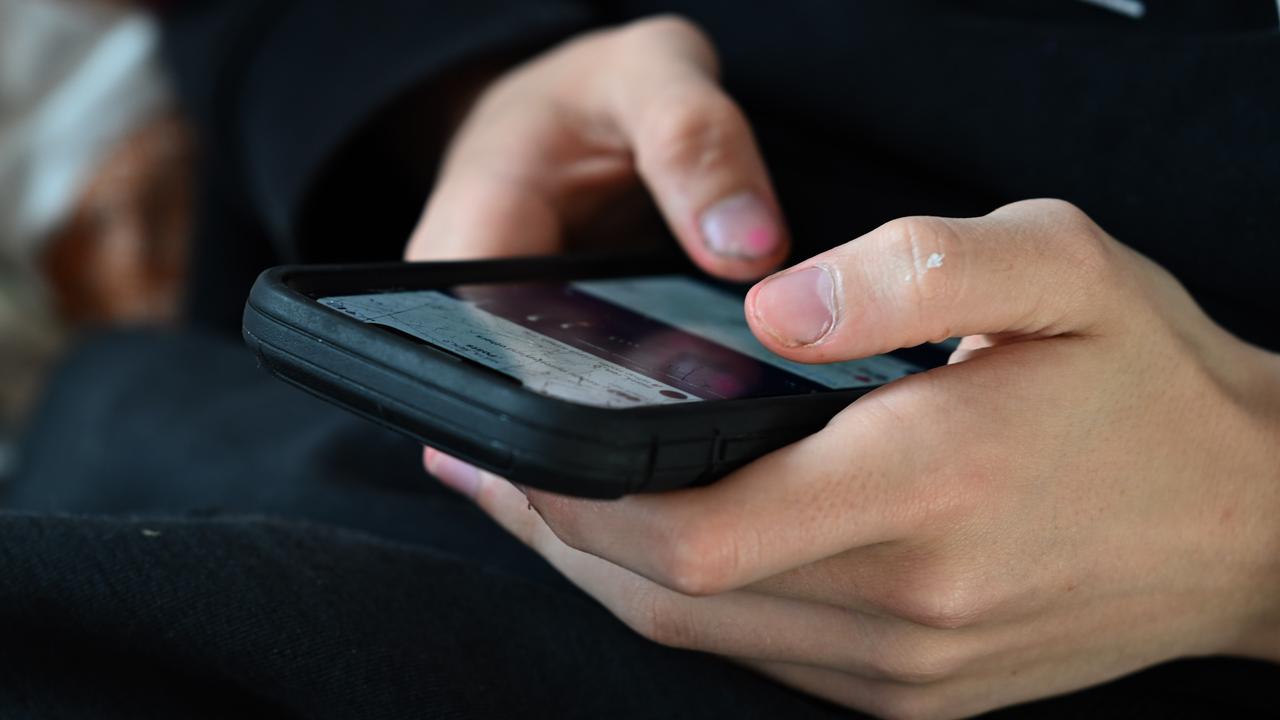 A teenager uses his mobile phone