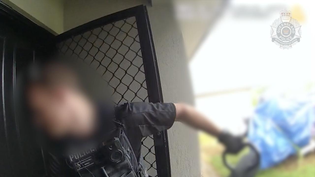 A police officer breaking through a door.