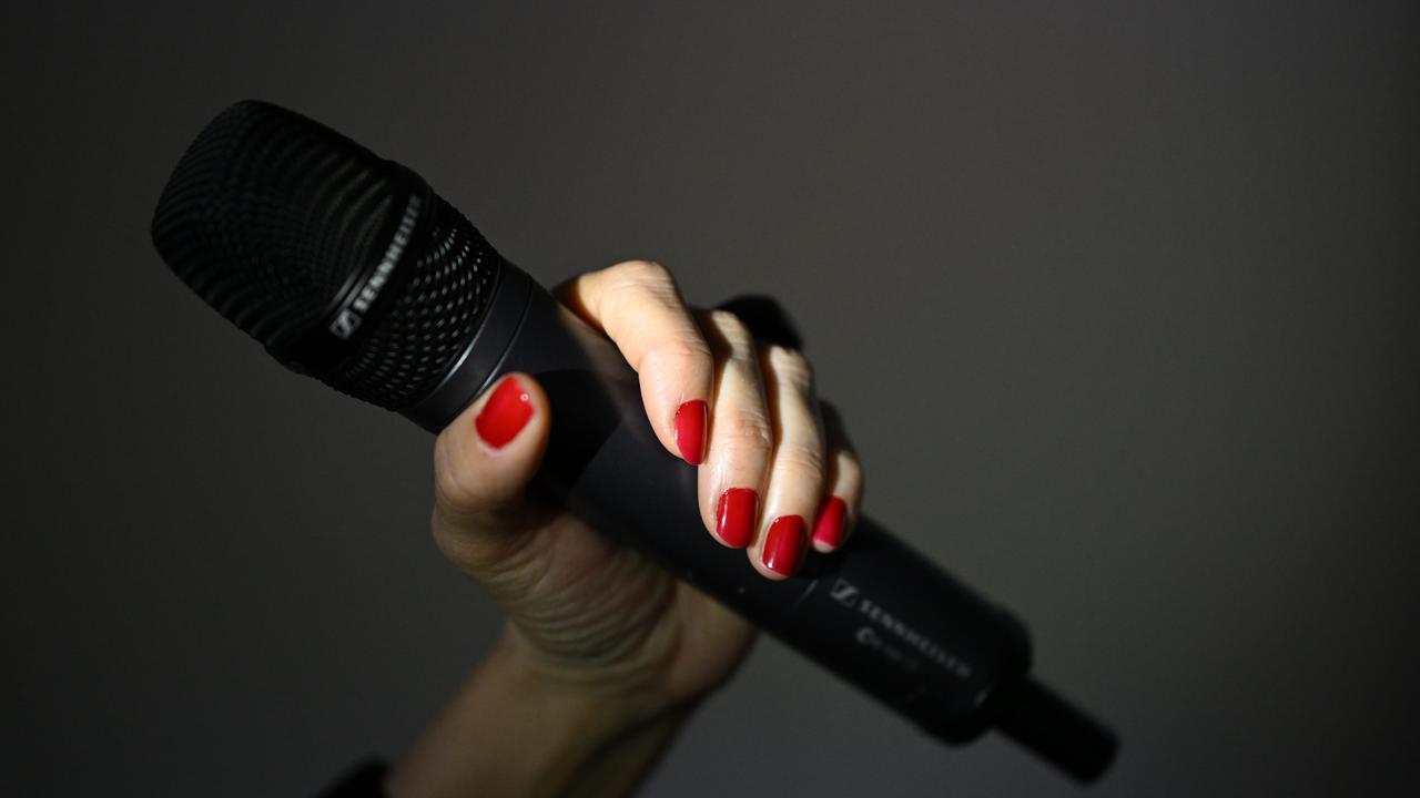 A hand holds a microphone