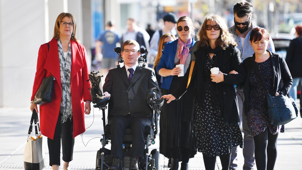 Jonathon Hawtin in wheelchair outside court with supporters 