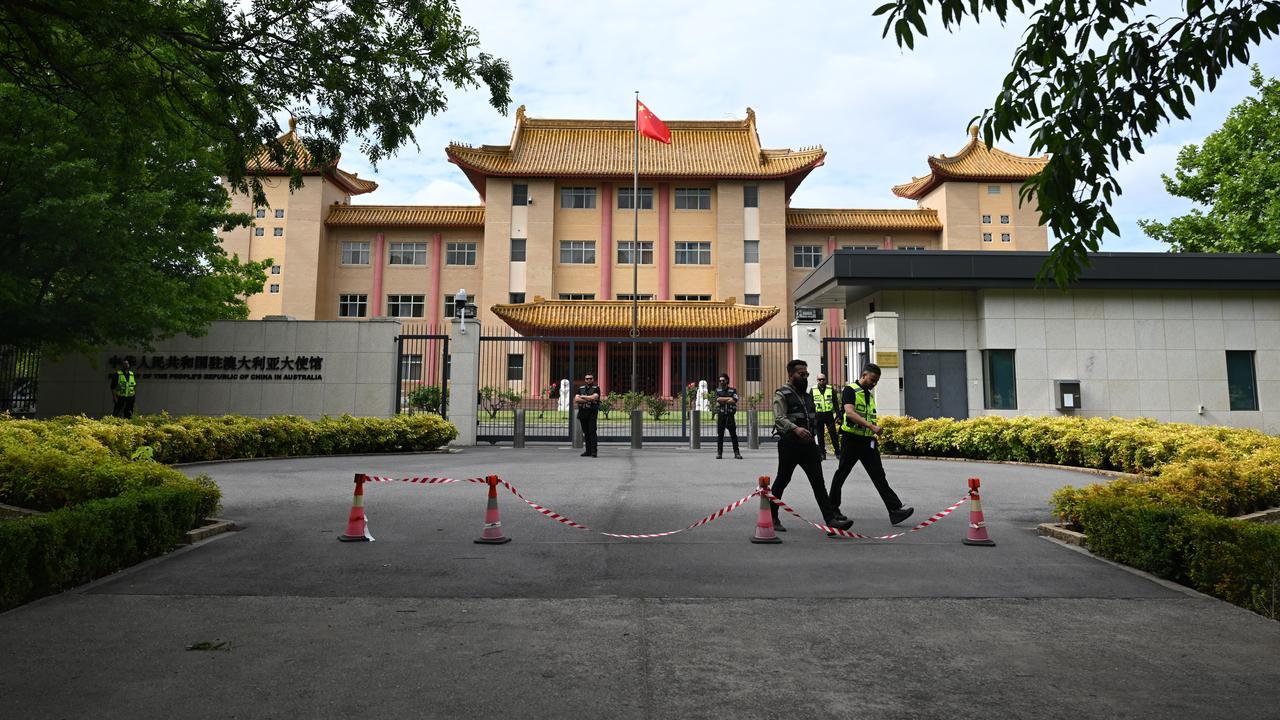 Security guards stand near the Chinese Embassy