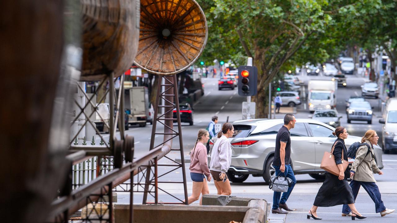 People walk past Chris Reynolds's sculpture "A History Apparatus