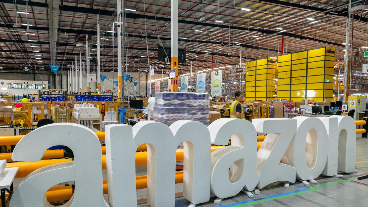 Workers move goods at Amazon's warehouse
