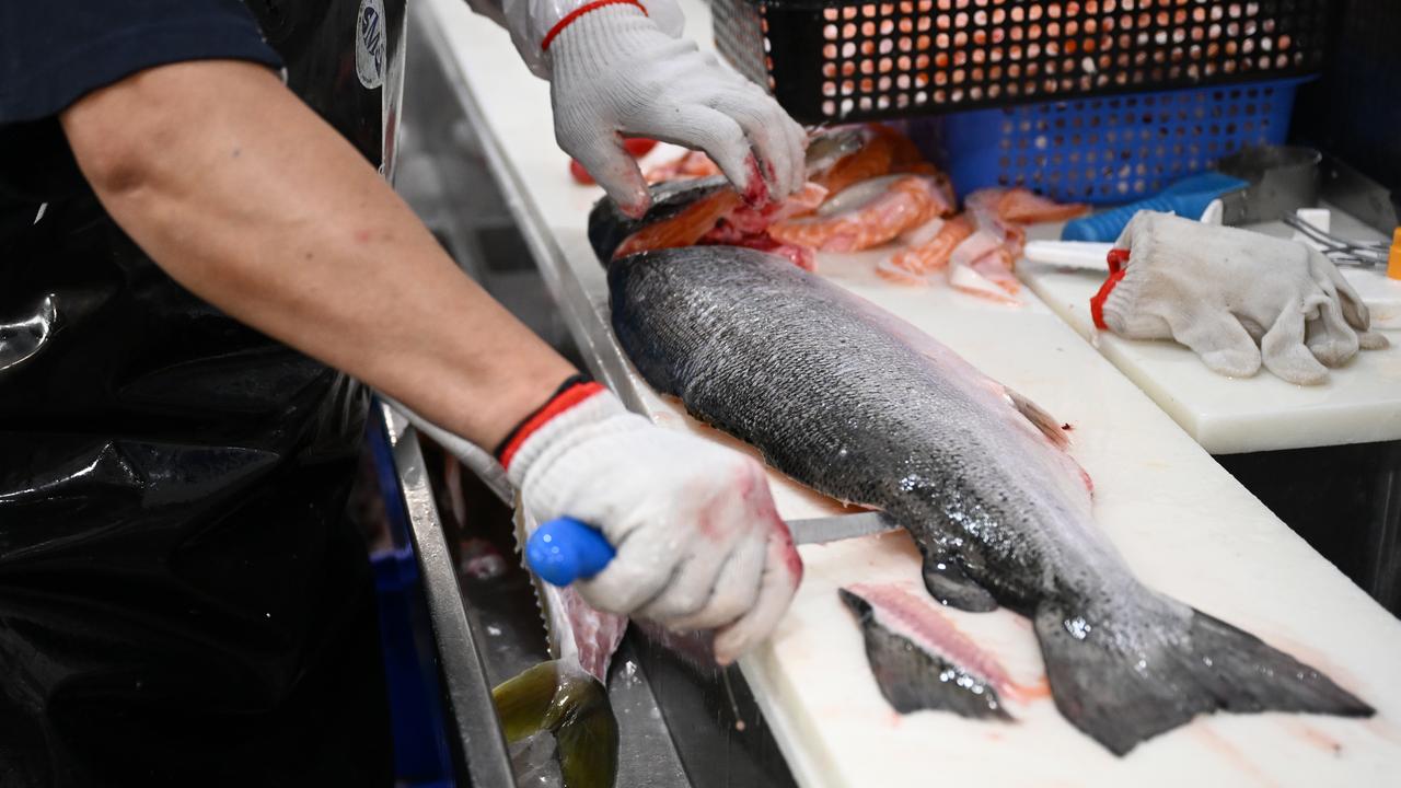 A worker prepares fish at the South Melbourne Market