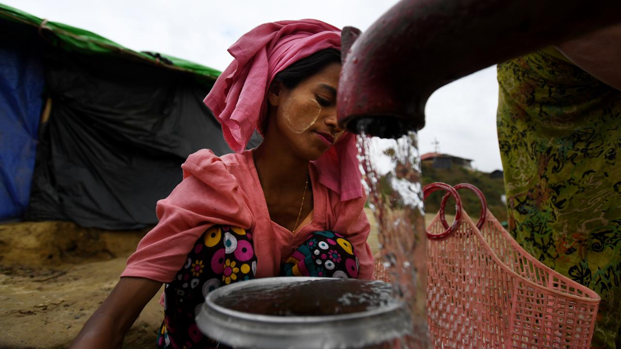 Rohingya women fill water jugs at a refugee camp (file image)
