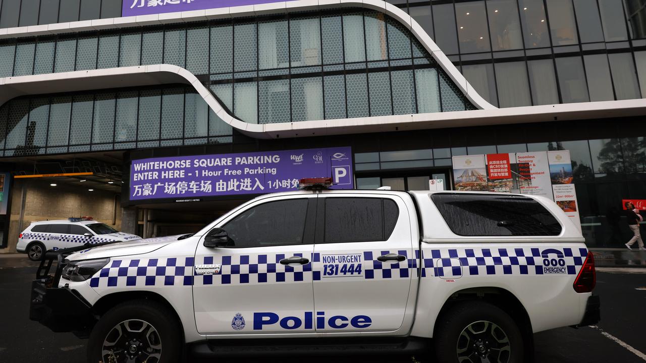 Police cars are seen outside the scene of a shooting in Box Hill