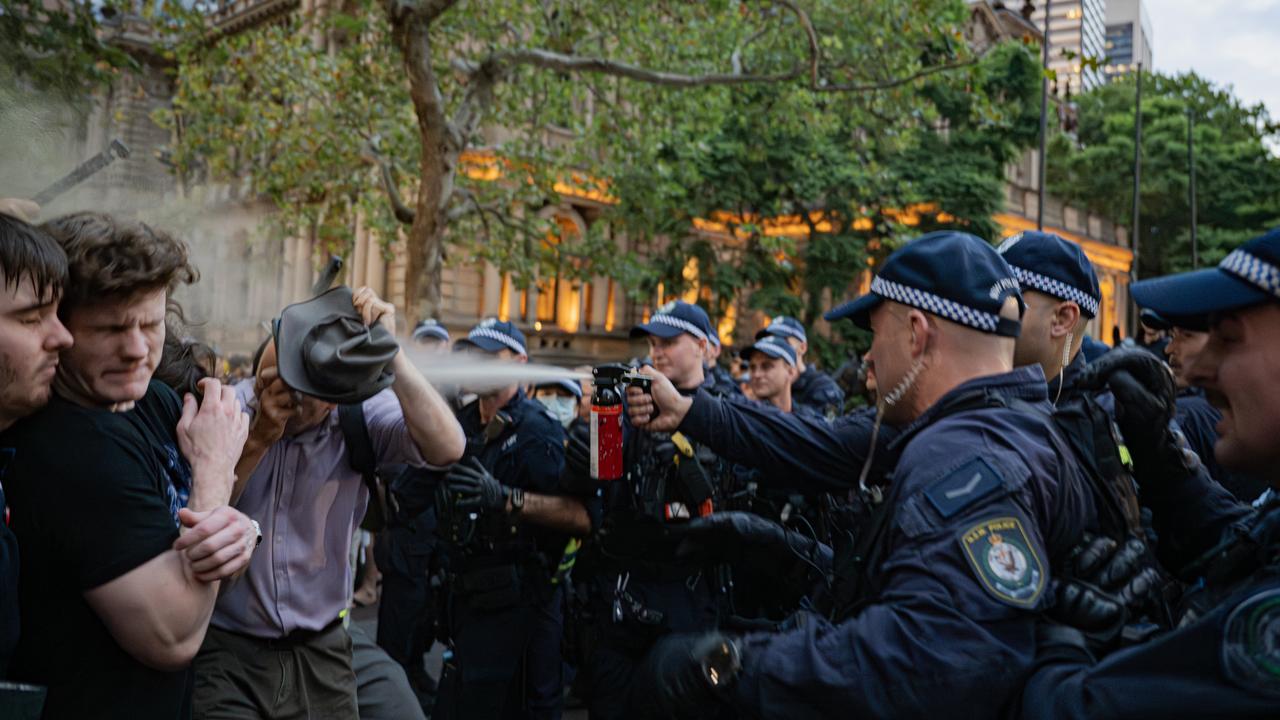 Demonstrators react to pepper spray during a protest in Sydney