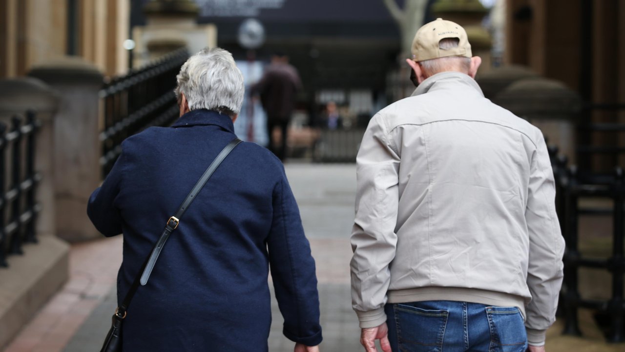 Elderly people walk down a street (file image)