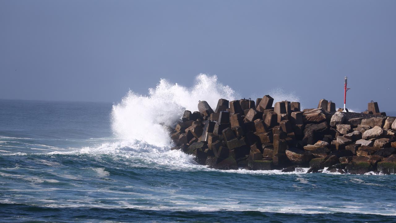A wave crashes into the South Ballina break wall in NSW